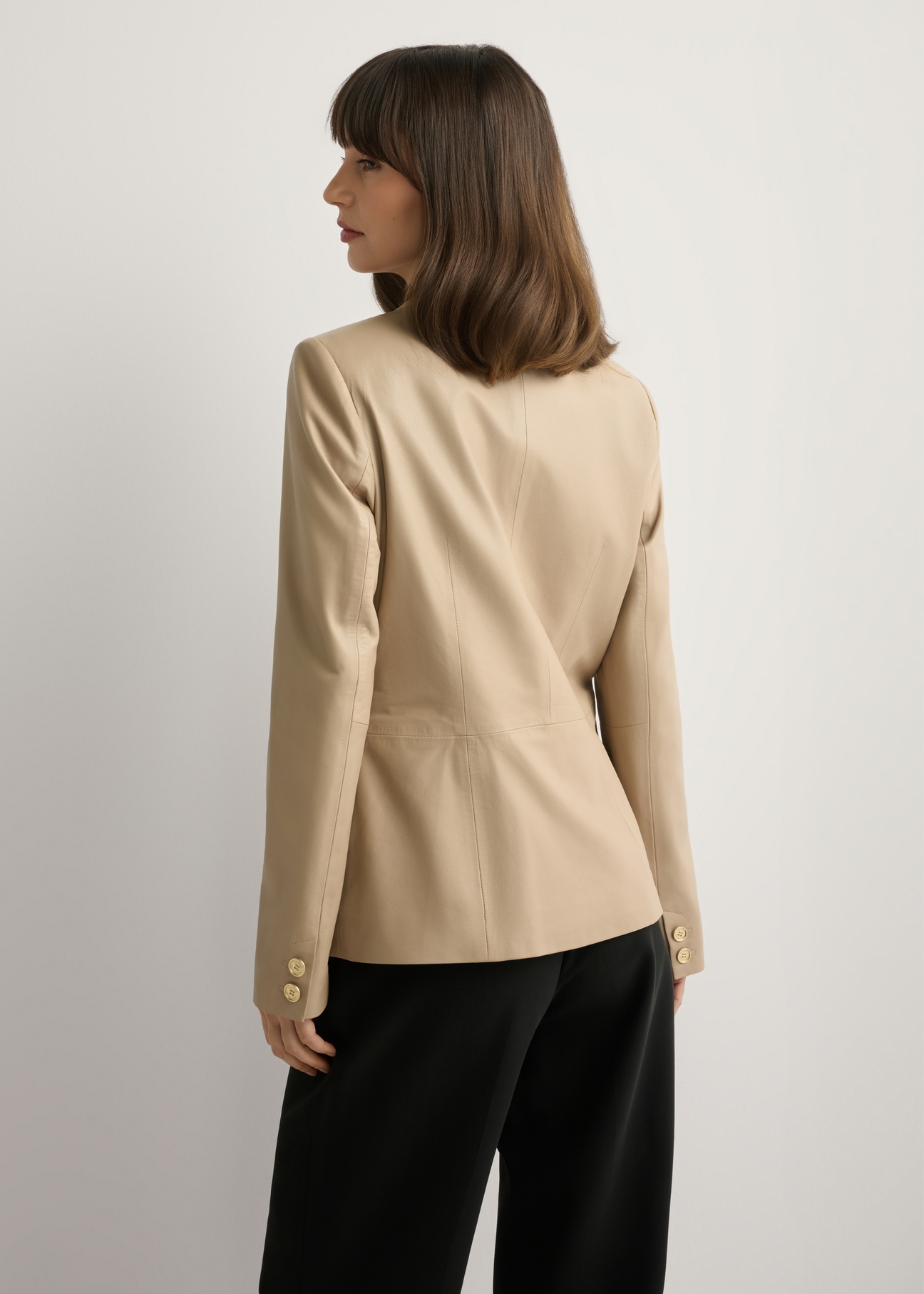 Dámska béžová kožená bunda KURDS-0445-1B(W26), pohľad na modelku zozadu. Viditeľná polovica siluety.