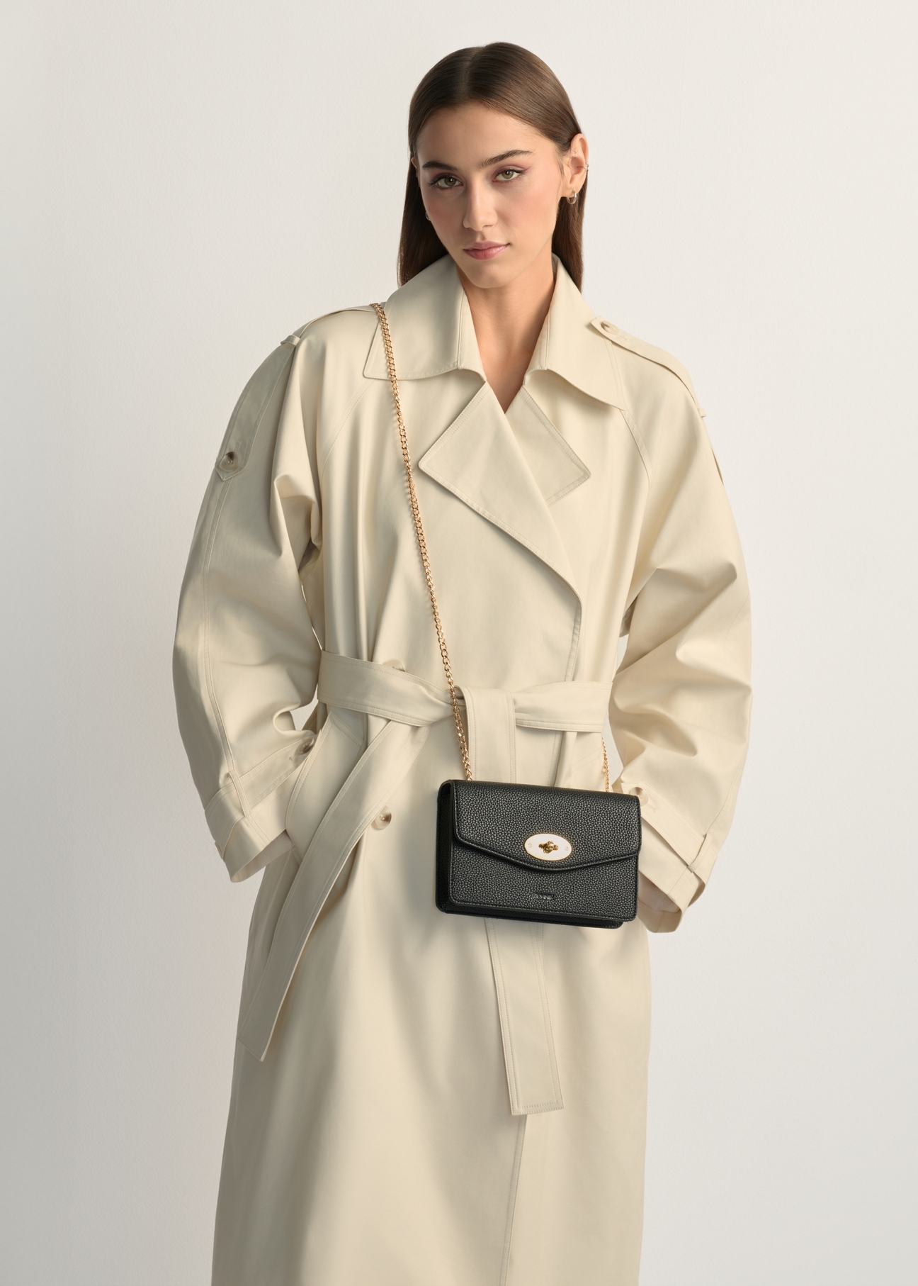 Malá čierna dámska kabelka TOREC-1141-9I(W26), pohľad na produkt na ramene modelky. Viditeľná polovica siluety.