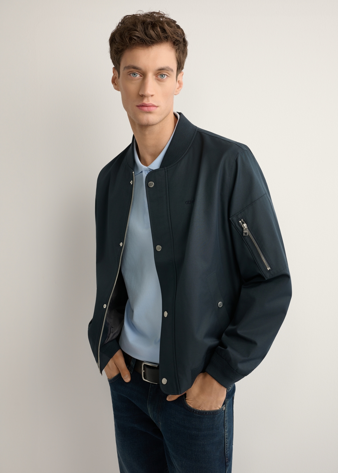 Pánska tmavomodrá prechodná bunda KURMT-0403-7D(W26), bočný pohľad na produkt na modelke. Viditeľná polovica siluety.