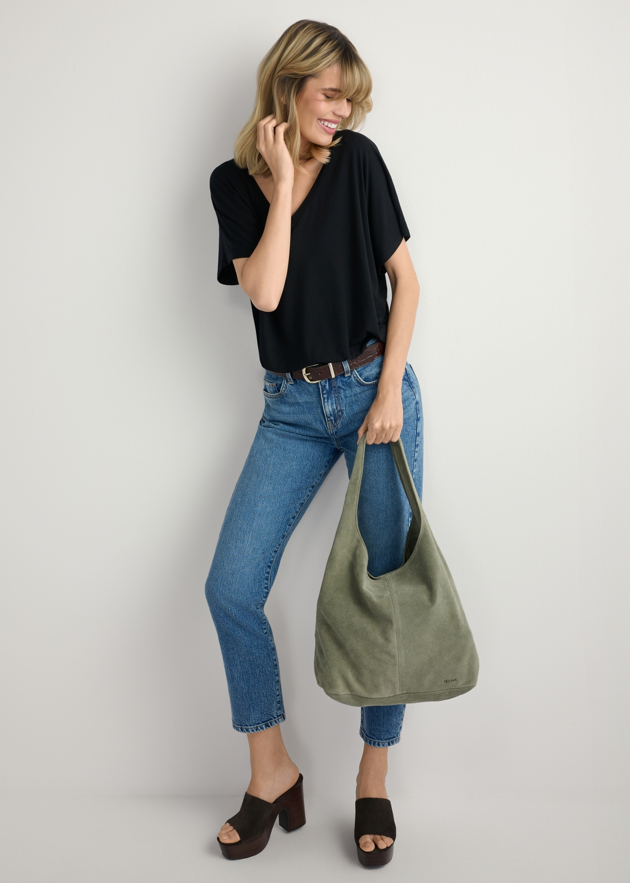 Dámska nákupná taška TORES-1177-8F(W26) zo semišu v šalviovej farbe - pohľad spredu na produkt, na modelke, na svetlom pozadí. Viditeľná celá postava.