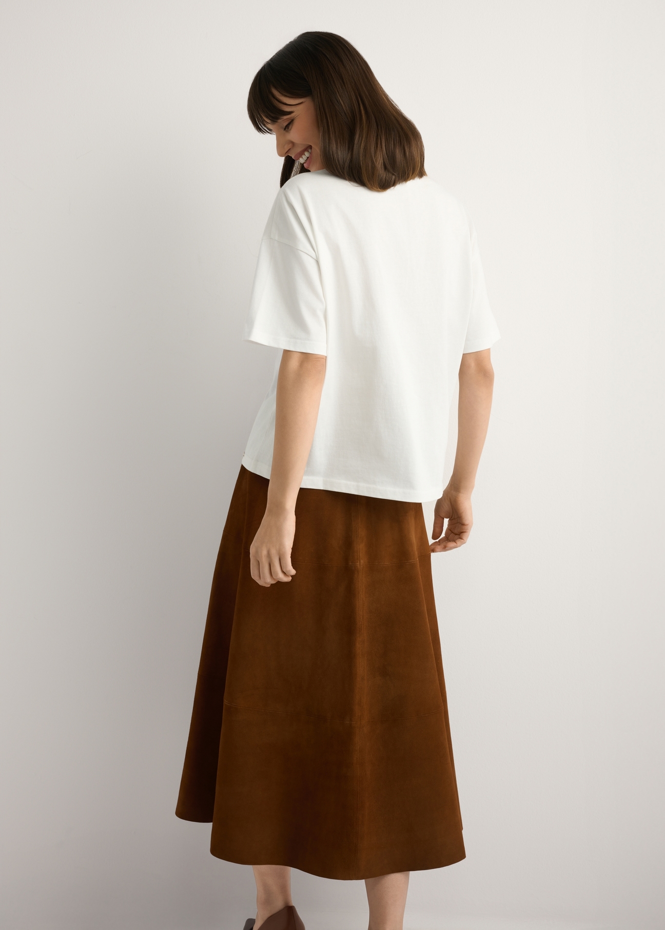 Dámske biele tričko s potlačou TSHDT-0153-0B(W26), pohľad na produkt zozadu na modelke. Viditeľná polovica siluety.