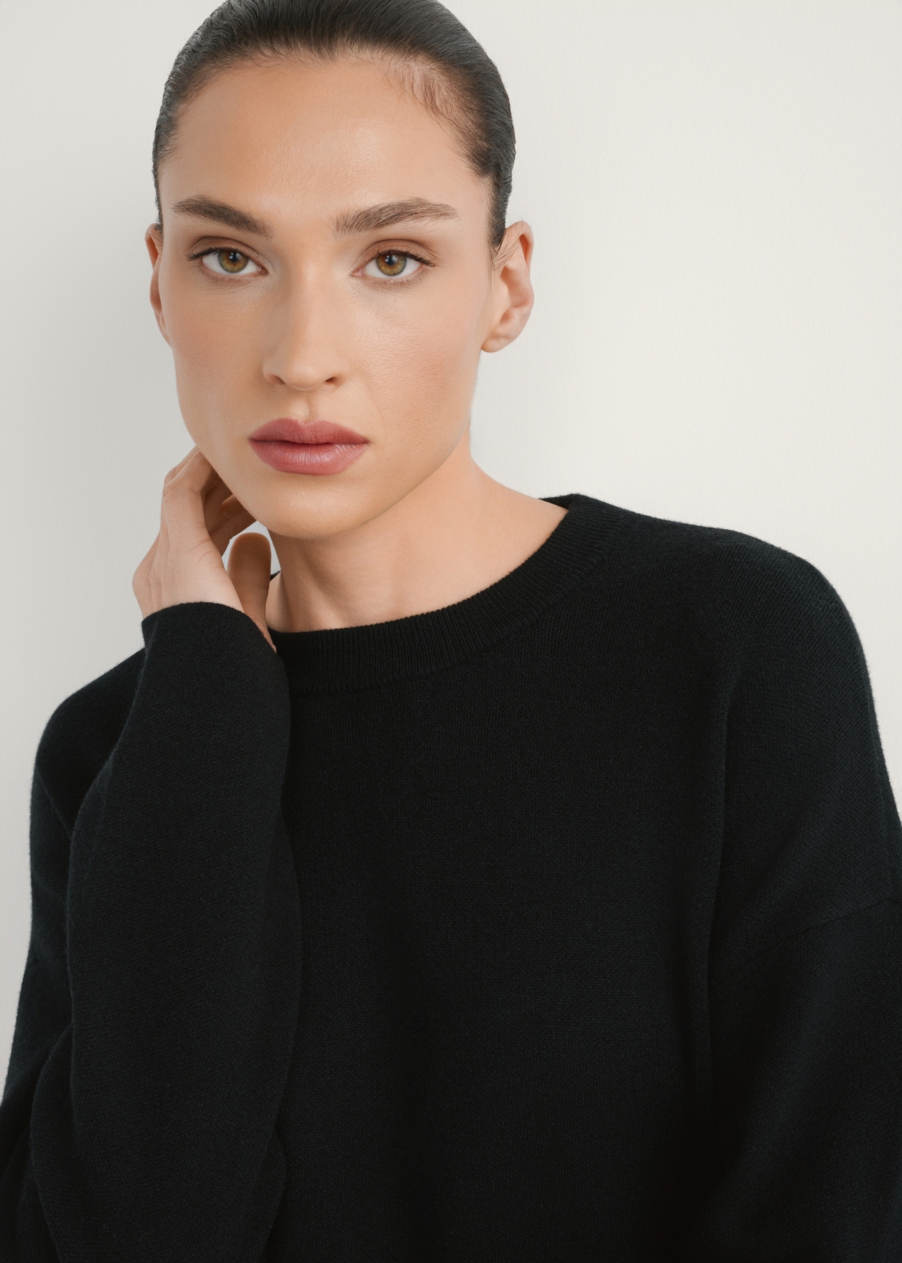 Čierne dámske šaty SUKDT-0260-99(W26), pohľad spredu na výrobok na modelke, detailný záber na tvár.