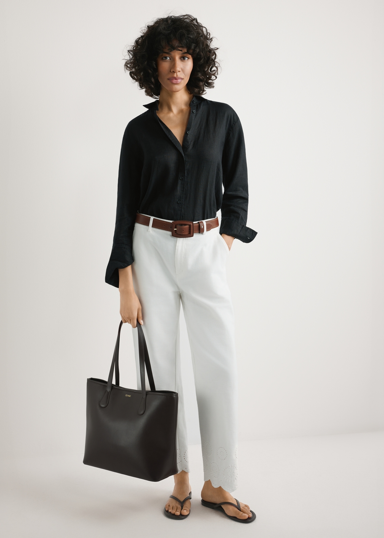 Hnedá dámska nákupná taška TOREC-1235-1H(W26), pohľad na produkt v rukách modelky. Viditeľné celé telo.