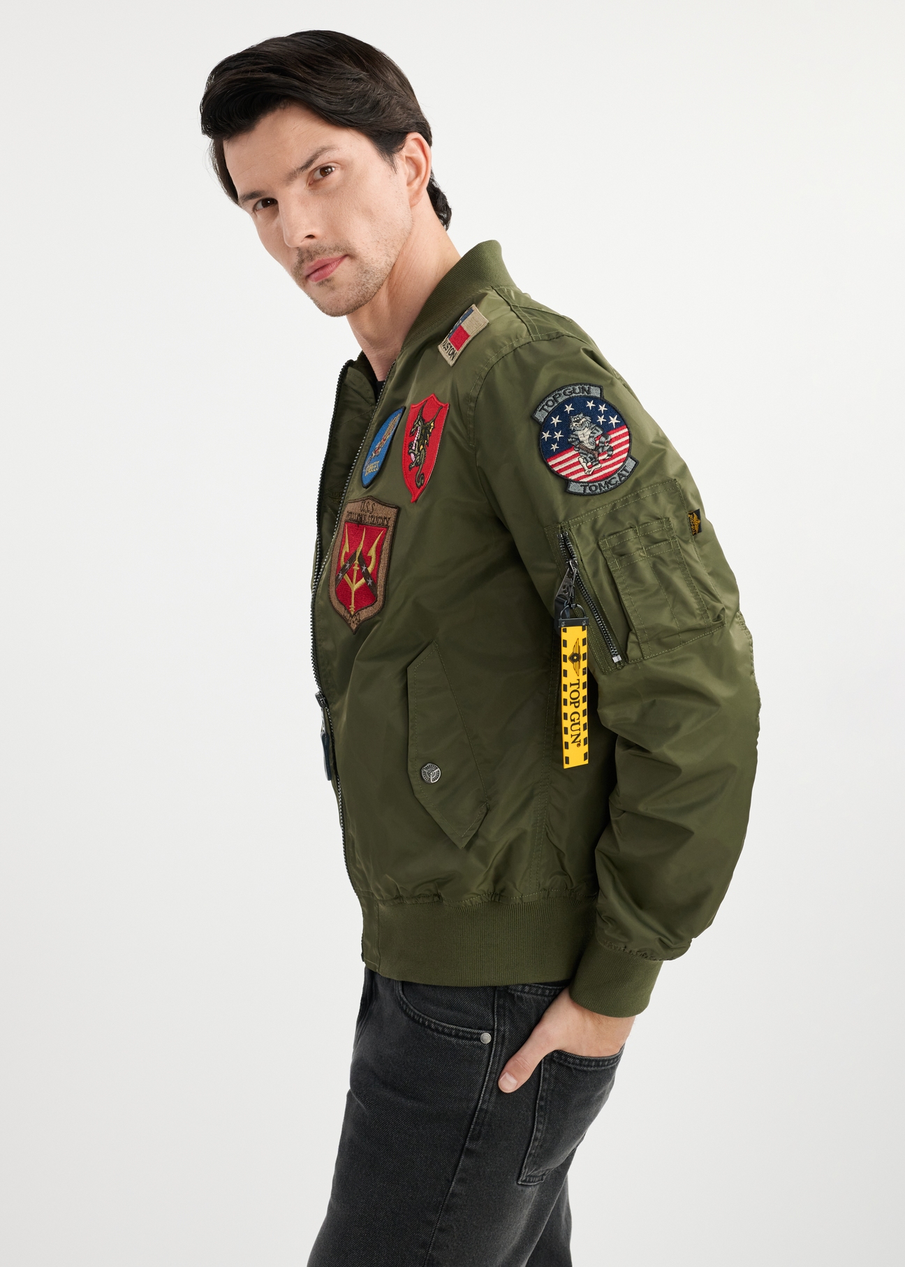Pánska olivovozelená bomber bunda TOP GUN KURMT-0381-57(W25) - bočný pohľad na modelku na bielom pozadí. Viditeľná je polovica siluety.