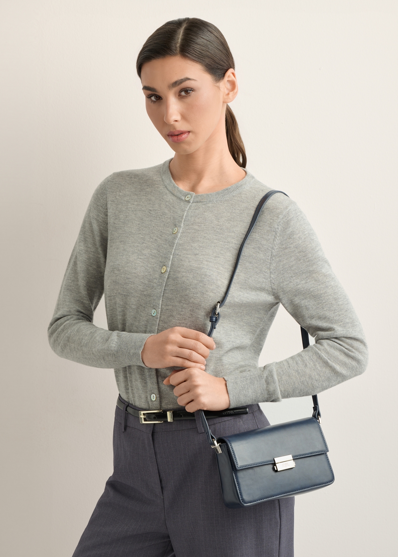 Elegantná dámska kabelka v tmavomodrej farbe TOREC-1251-7E(Z26), diagonálny pohľad na produkt na modelke. Viditeľná polovica siluety.