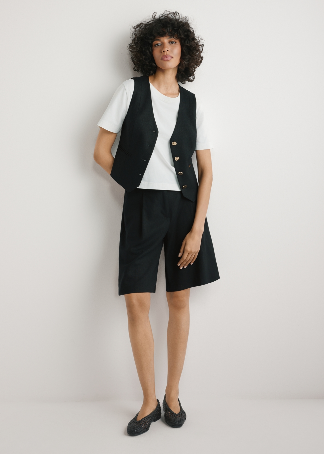 Čierna vesta z viskózy a ľanu KAMDT-0038-99(W26) - pohľad spredu na produkt, na modelke, na svetlom pozadí, viditeľná celá silueta.