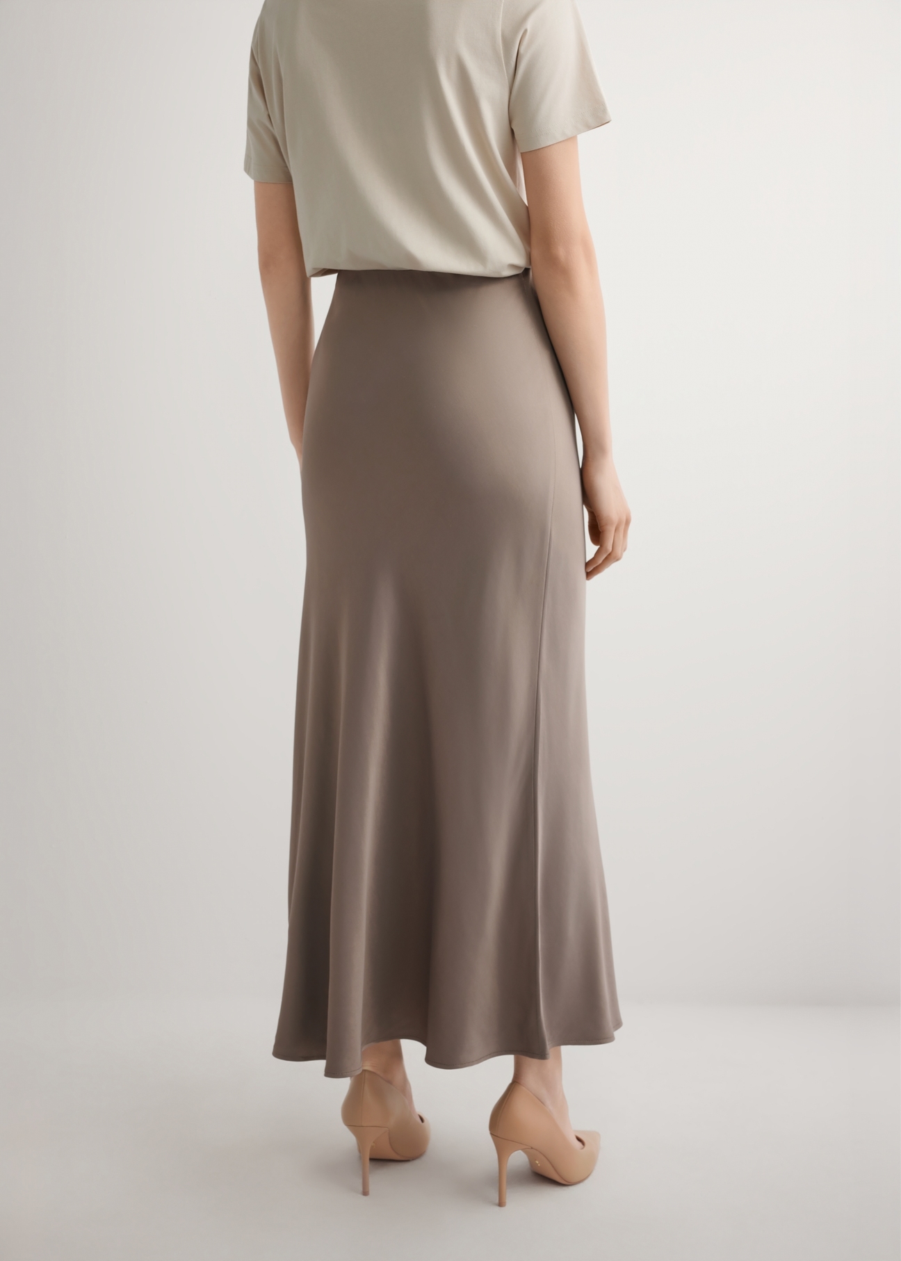 Hnedá dámska sukňa SPCDT-0122-1K(W26), pohľad zozadu na modelku. Viditeľná polovica siluety.