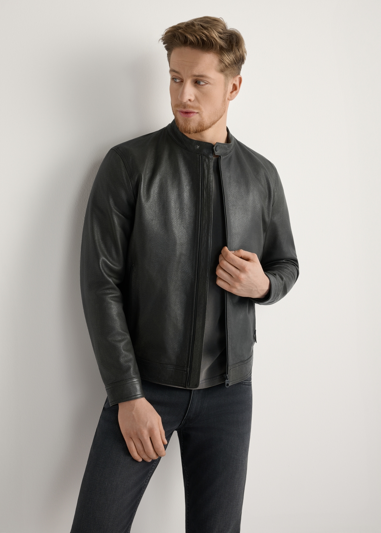 Čierna pánska kožená bunda KURMS-0406-99(W26) - pohľad spredu na modelku na svetlom pozadí. Viditeľná silueta po kolená.