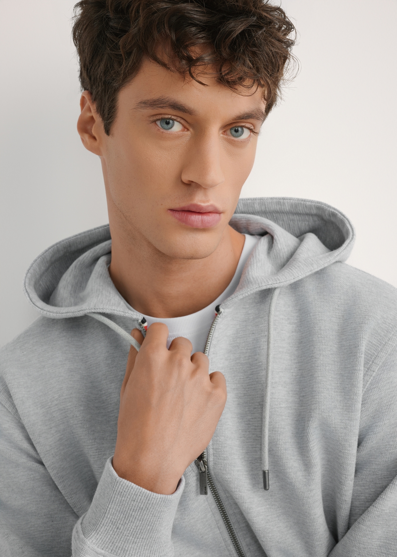 Pánska sivá mikina s kapucňou BLZMT-0079-9A(W26), detailný záber produktu na modelke.