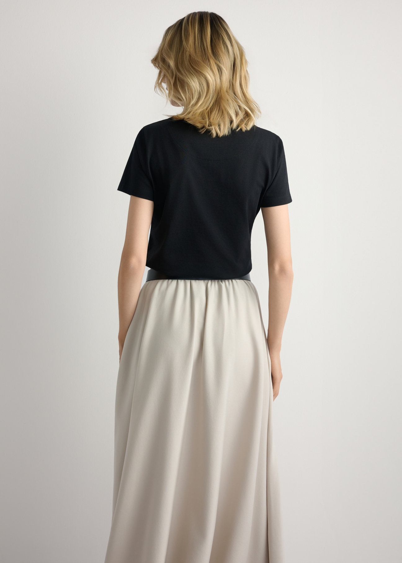 Čierne dámske tričko s logom TSHDT-0157-99(W26), pohľad na produkt zozadu na modelke. Viditeľná polovica siluety.