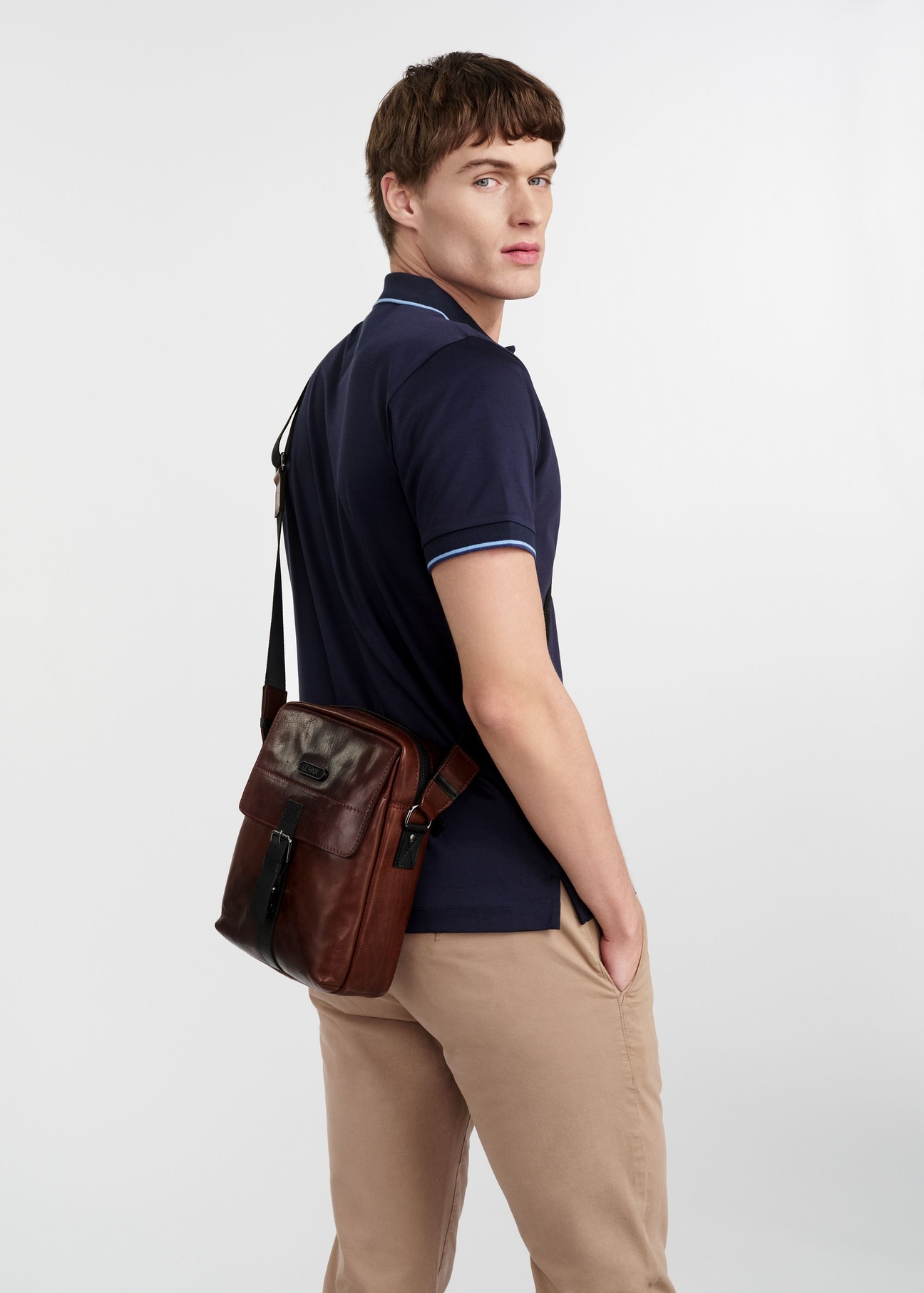 Hnedá kožená pánska taška TORMS-0104-1H(W26), bočný pohľad na produkt na siluete modelky, na svetlom pozadí.