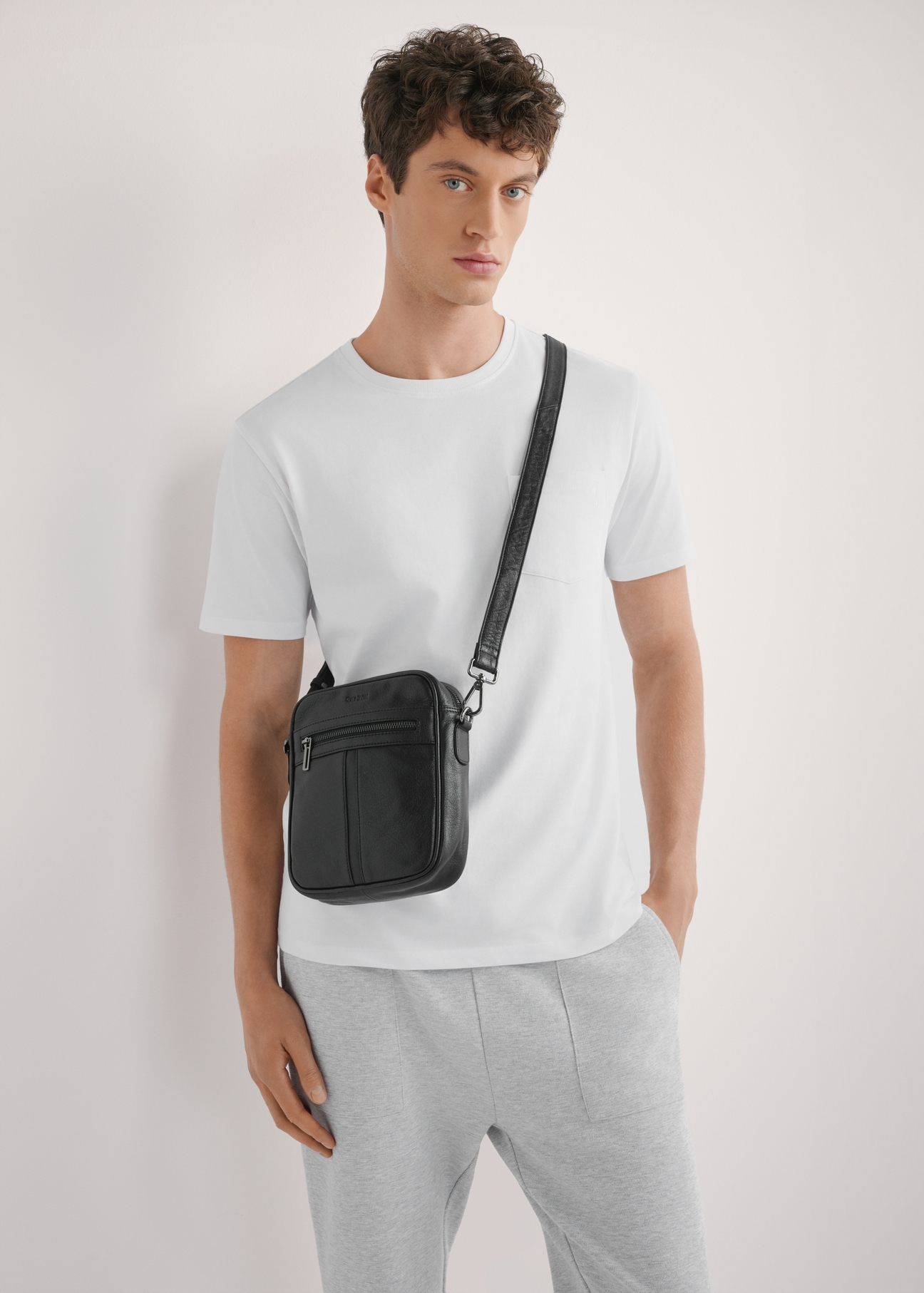 Schwarze Herren-Ledertasche TORMS-0491-99(W26) – Produktansicht leicht schräg, am Model, vor hellem Hintergrund. Die Silhouette ist zur Hälfte sichtbar.