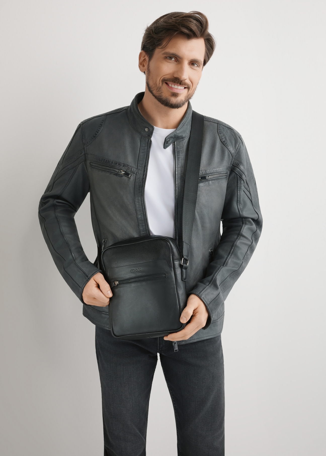 Pánska čierna kožená taška cez rameno TORMS-0499-99(W26), pohľad na produkt na ramene modelu. Viditeľná polovičná silueta.