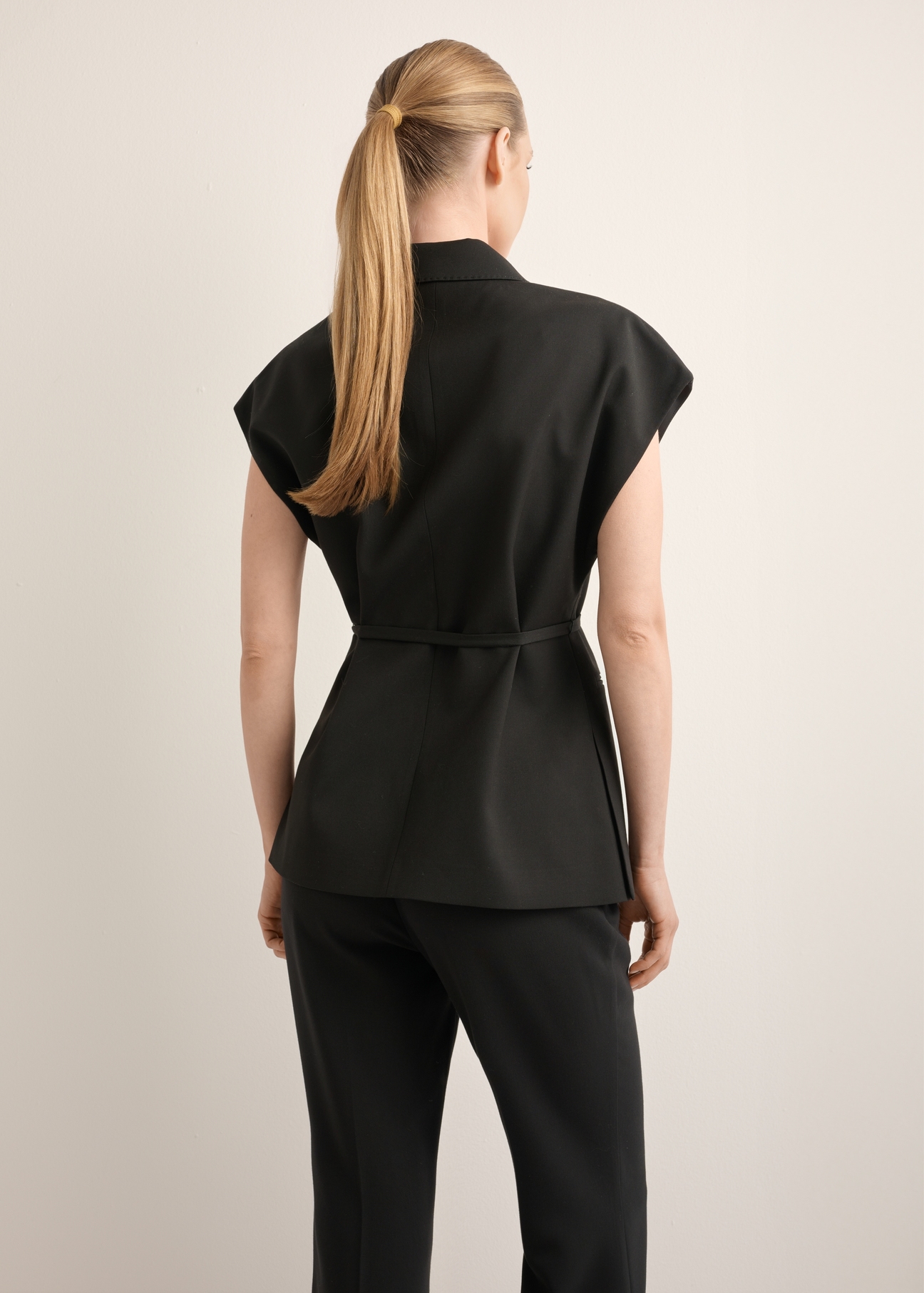 Dámska čierna oversize vesta KAMDT-0039-99(Z26), pohľad zozadu na produkt na modelke. Viditeľná polovica siluety.