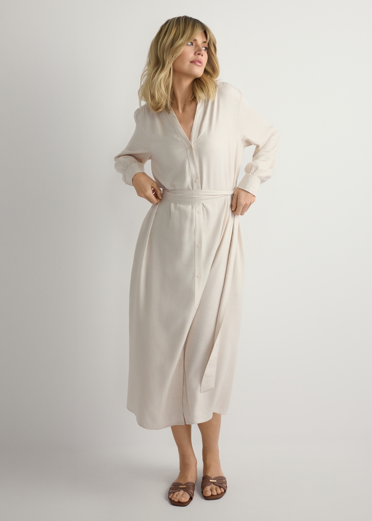 Svetlobéžové dámske midi šaty SUKDT-0269-1A(W26), pohľad spredu na výrobok na modelke. Viditeľná polovica siluety.