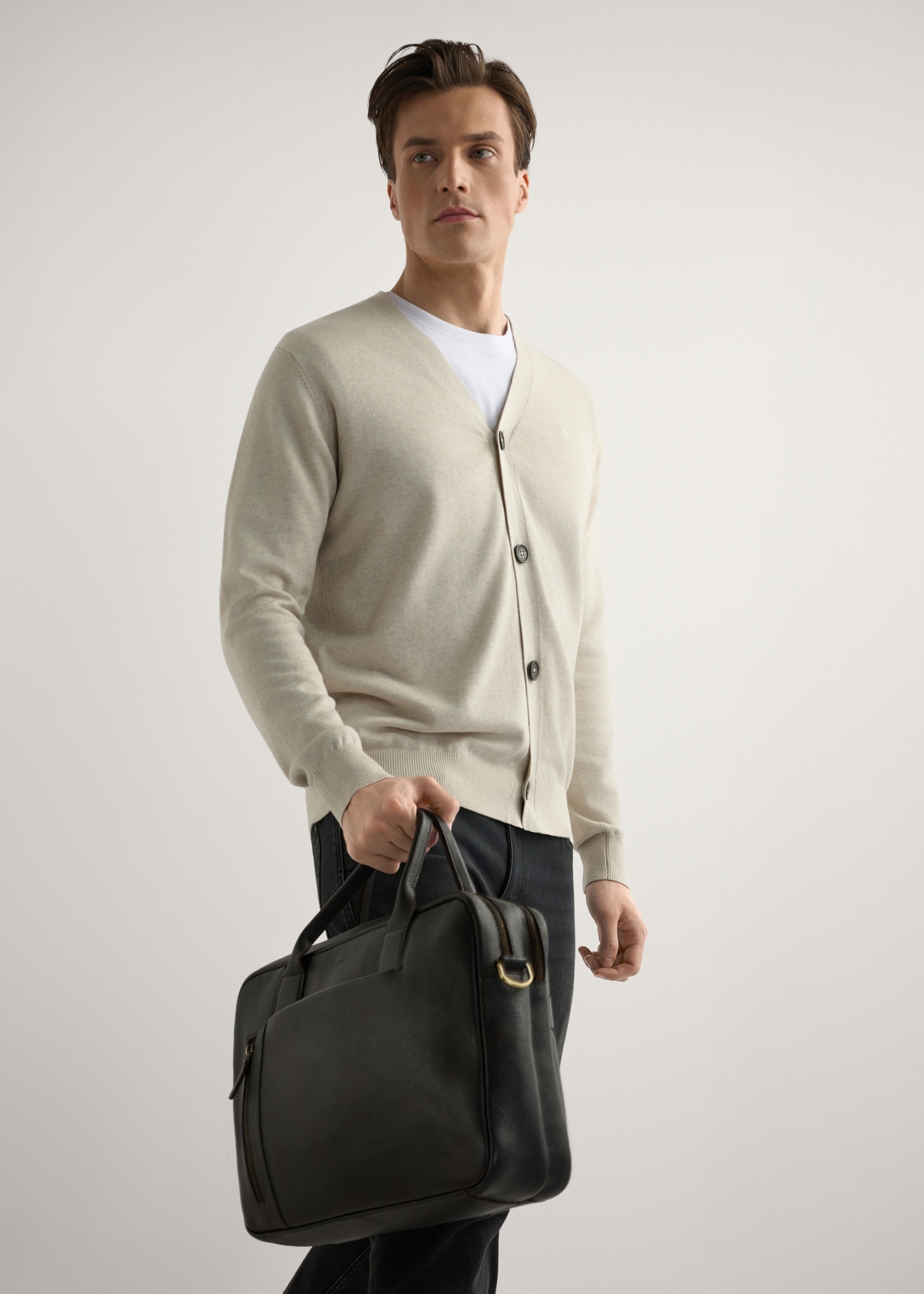 Hnedá pánska kožená taška TORMS-0504-1I(W26), diagonálny pohľad na produkt v ruke modelu. Viditeľná polovica siluety.