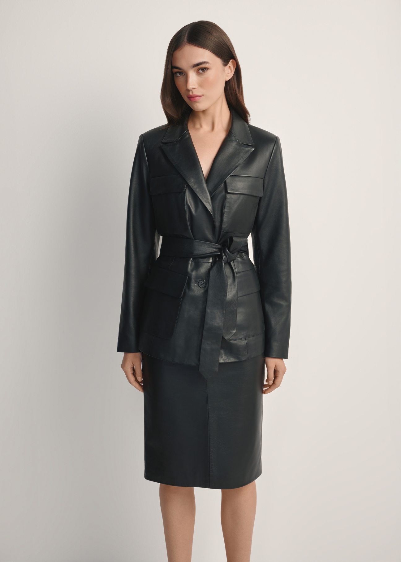 Dámska čierna kožená bunda s opaskom KURDS-0545-99(W26), pohľad spredu na produkt na modelke. Viditeľná polovica siluety.