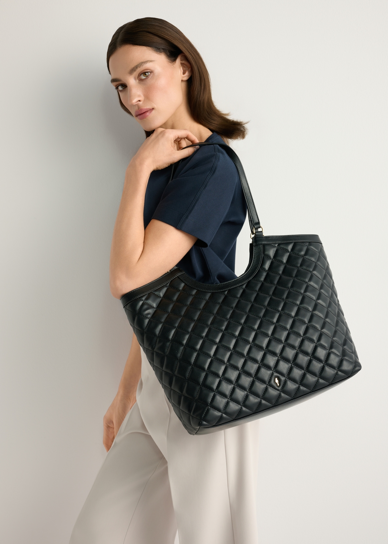 Veľká prešívaná dámska kabelka TOREC-1118-99(W26), pohľad na produkt na ramene modelky, na svetlom pozadí.