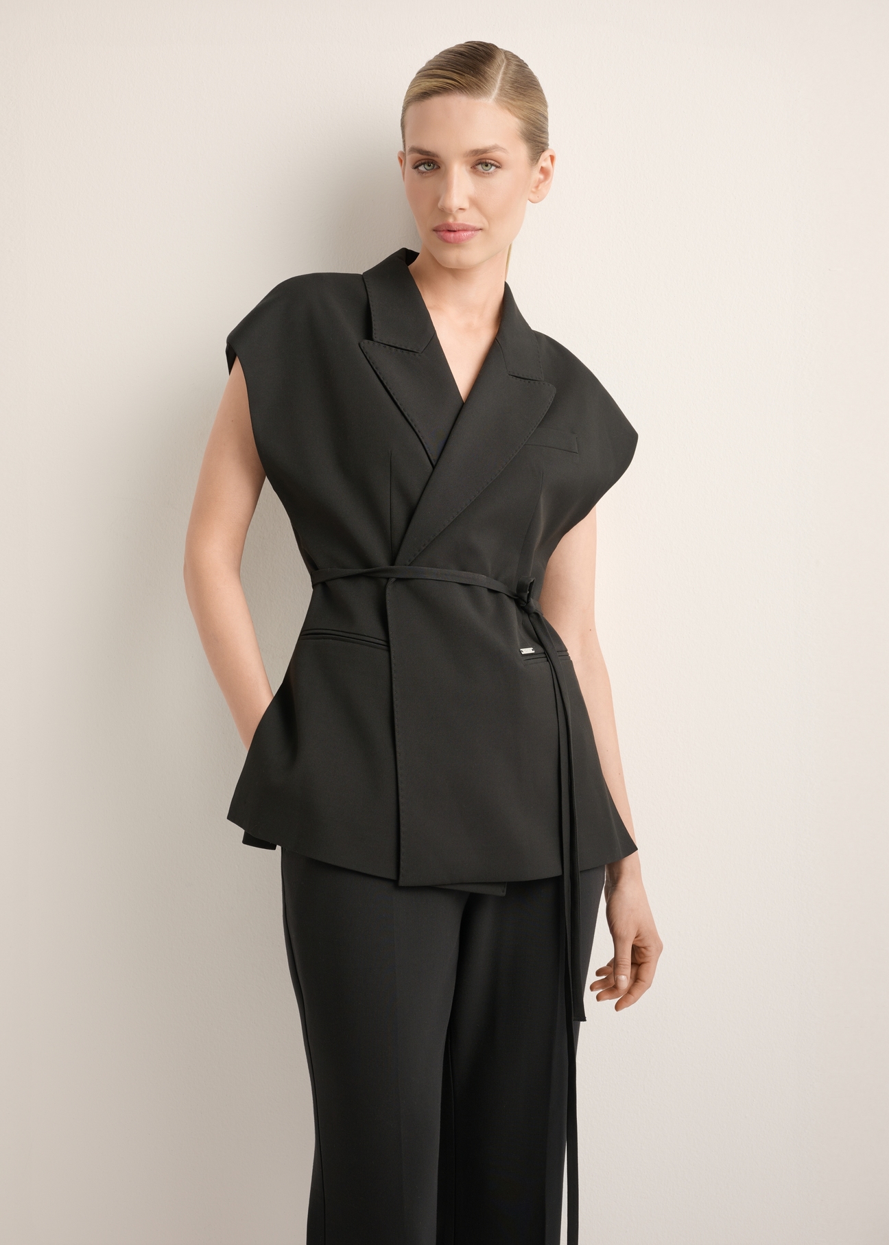 Dámska čierna oversize vesta KAMDT-0039-99(Z26), pohľad spredu na produkt na modelke. Viditeľná polovica siluety.