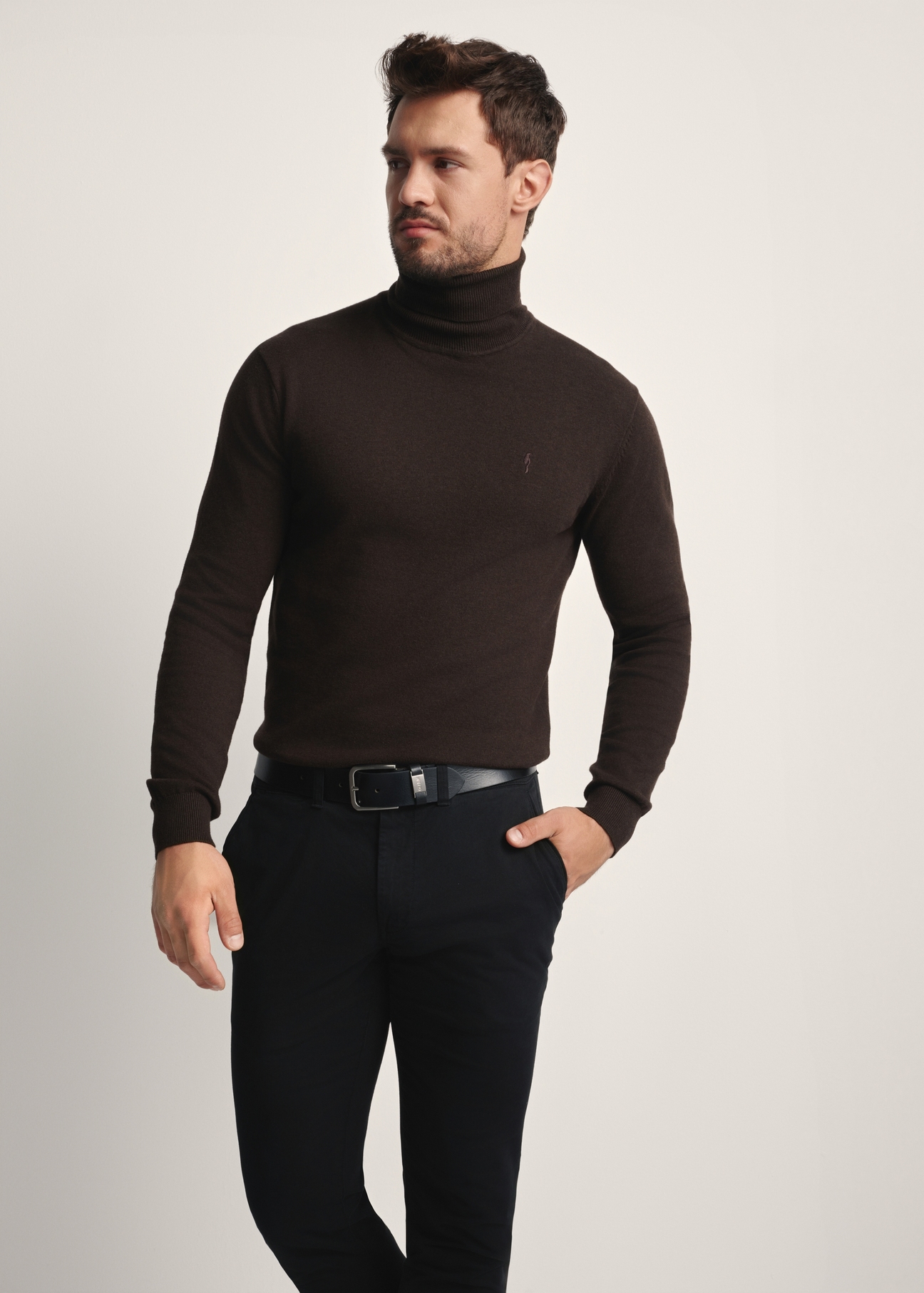 Pánsky rolák v čokoládovej farbe SWEMT-0095B-90(Z25), pohľad na produkt spredu na modelke, viditeľná polovica siluety.