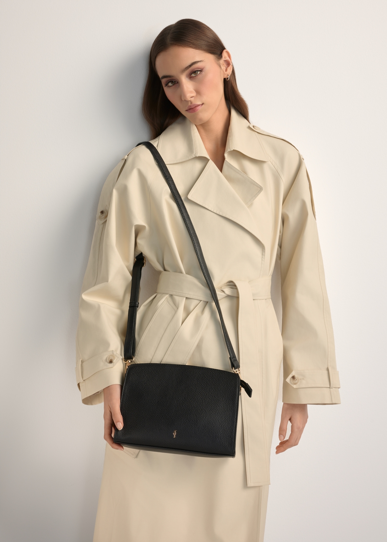 Čierna kožená dámska kabelka strednej veľkosti TORES-1279-9I(W26), pohľad na produkt na ramene modelky. Viditeľná polovica siluety.