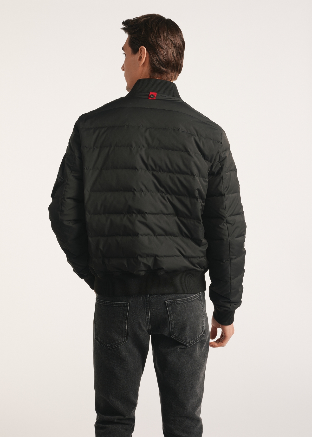 Čierna zateplená pánska bomber bunda KURMT-0362-99(Z25), produkt viditeľný zozadu na modeli, viditeľná polovica siluety.