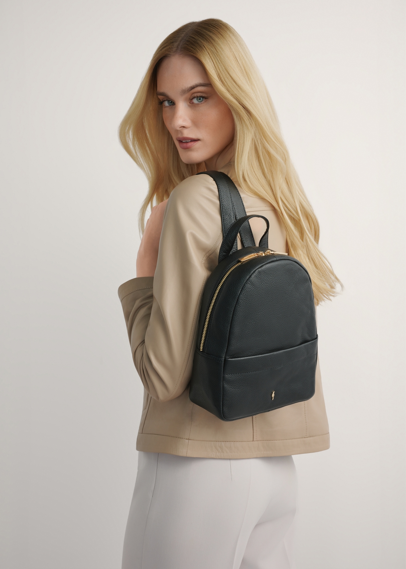 Čierny stredne veľký kožený dámsky batoh TORES-1268-9I(W26), pohľad na produkt spredu na modelke, viditeľná polovica siluety.