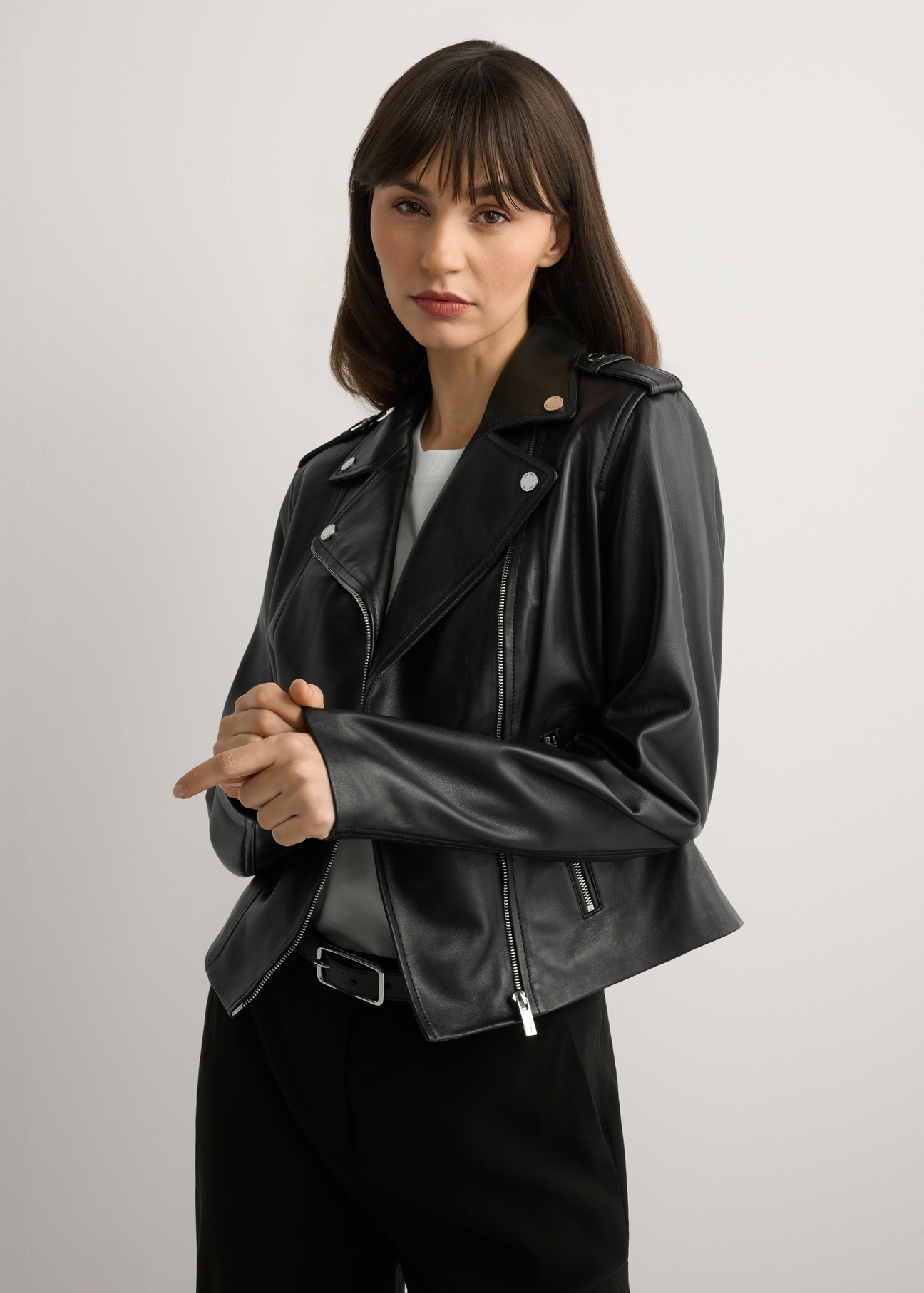 Dámska čierna kožená bunda KURDS-0601-99(W26), pohľad spredu na produkt na modelke. Viditeľná polovica siluety.