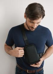 Čierna malá pánska taška TORMN-0390-99(W26), pohľad na produkt na siluete modelky, na svetlom pozadí.