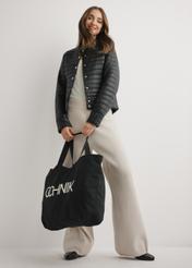 Čierna bavlnená taška TOREN-0136-9P(W26), pohľad na produkt v ruke modelky. Viditeľné celé telo.