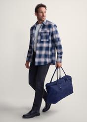 Námornícka modrá cestovná taška TORMN-0382-69 (Z25), pohľad na produkt v ruke modelky. Viditeľné celé telo.