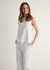 Dámska biela blúzka BLUDT-0207-0B(W26), pohľad spredu na produkt na modelke. Viditeľná polovica siluety.