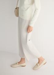 Dámske krémové kožené mokasíny s retiazkou BUTYD-0914A-0B(W26), bočný pohľad na produkt na modelke, viditeľná polovica siluety.