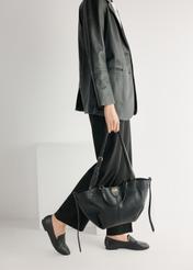 Dámske čierne kožené mokasíny BUTYD-1074A-99(W26), pohľad na produkt spredu na modelke, viditeľná polovica siluety.