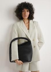 Čierna tkaná nákupná taška TOREC-1148-99(W26) - pohľad na produkt držaný v ruke modelky na svetlom pozadí. Viditeľná je polovica siluety.