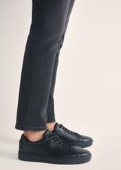 Čierne kožené športové topánky BUTYM-0503A-99(W26), bočný pohľad na produkt na nohách modelky.