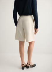 Dámske krémové vlnené šortky SZODT-0021-0B(W26), pohľad na modelku zozadu. Viditeľná polovica siluety.
