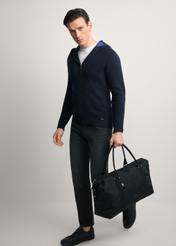 Čierna cestovná taška TORMN-0382-99(Z25) - diagonálny pohľad na produkt, ktorý drží modelka, na svetlom pozadí. Viditeľná je celá silueta.