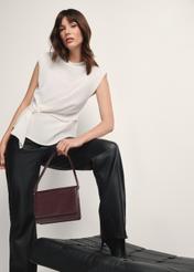 Dámska kožená kabelka v bordovej farbe TORES-1189-49(Z25), pohľad na produkt v ruke modelky na svetlom pozadí.
