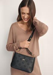 Čierna dámska kabelka s monogramom TOREC-1159-9P(W26), pohľad spredu na produkt na modelke, viditeľná polovica siluety.