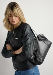 Čierna dámska lesklá kabelka TOREC-1205-9F(W26) - pohľad na produkt mierne diagonálny, na modeli na svetlom pozadí. Viditeľná polovica siluety.