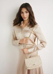 Dámska lakovaná kožená kabelka v krémovej farbe TORES-1297-0B(W26), pohľad spredu na produkt na modelke. Viditeľná silueta po kolená.