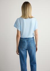 Svetlomodrá dámska blúzka BLUDT-0206-7A(W26), pohľad na modelku zozadu. Viditeľná polovica siluety.