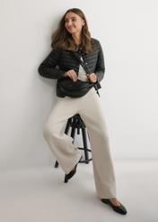 Čierna polkruhová dámska kabelka TOREC-1146-99(W26), pohľad na produkt na ramene modelky. Viditeľné celé telo.