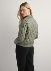 Dámska prechodná khaki bunda KURDT-0564A-55(W26), pohľad na modelku zozadu. Viditeľná polovica siluety.