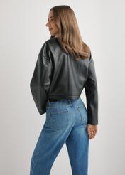 Dámska krátka čierna kožená bunda KURDS-0597-99(W26), pohľad na modelku zozadu. Viditeľná polovica siluety.