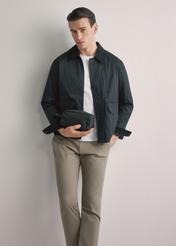 Čierna pánska kozmetická taška TORMN-0352-99(W26), pohľad spredu na produkt v ruke modelu. Viditeľná polovica siluety.