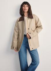 Béžová dámska oversize bunda KURDT-0615-81(Z25), pohľad spredu na produkt na modelke. Viditeľná polovica siluety.