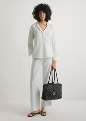 Tmavohnedá tkaná dámska kabelka TORES-1301-1I(W26), pohľad na produkt v ruke modelky. Viditeľné celé telo.