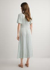 Dlhé kvetinové šaty v šalviovej farbe SUKDT-0191-8P(W26), pohľad zozadu na modelku. Viditeľné celé telo.